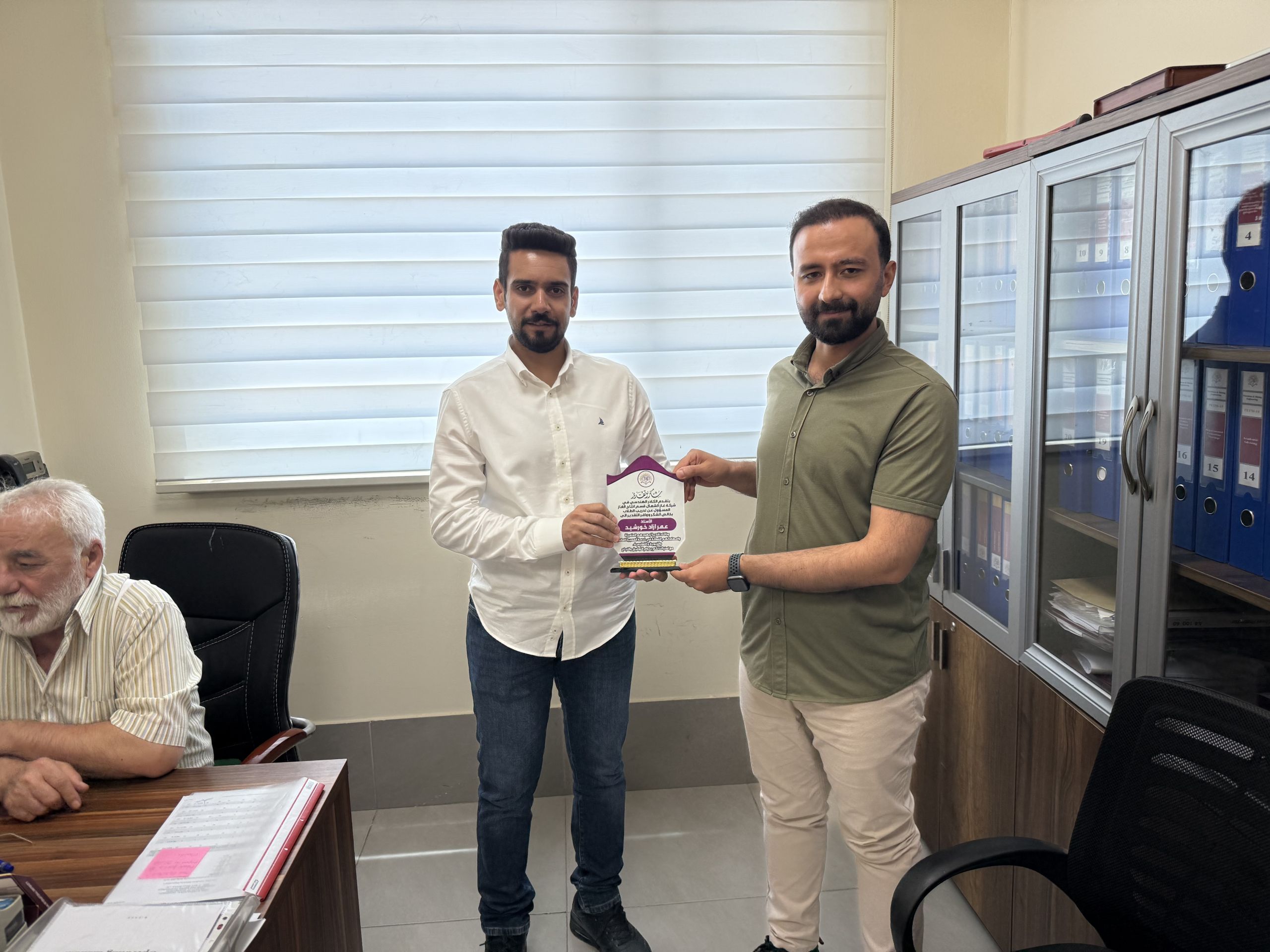 Engineer Mohaimen Mohammed Younis presenting an appreciation plaque to Mr. Omar Azad Khorsheed